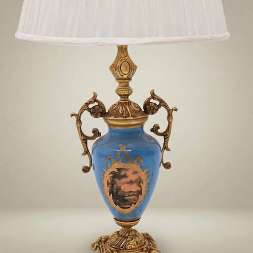Classical Blue Porcelain Urn Table Lamp with Ornate Brass Scrollwork Handles and Hand-Painted Landscape Medallion White Pleated Shade Brass and Wood Antique Gold Front | Brass & Wood